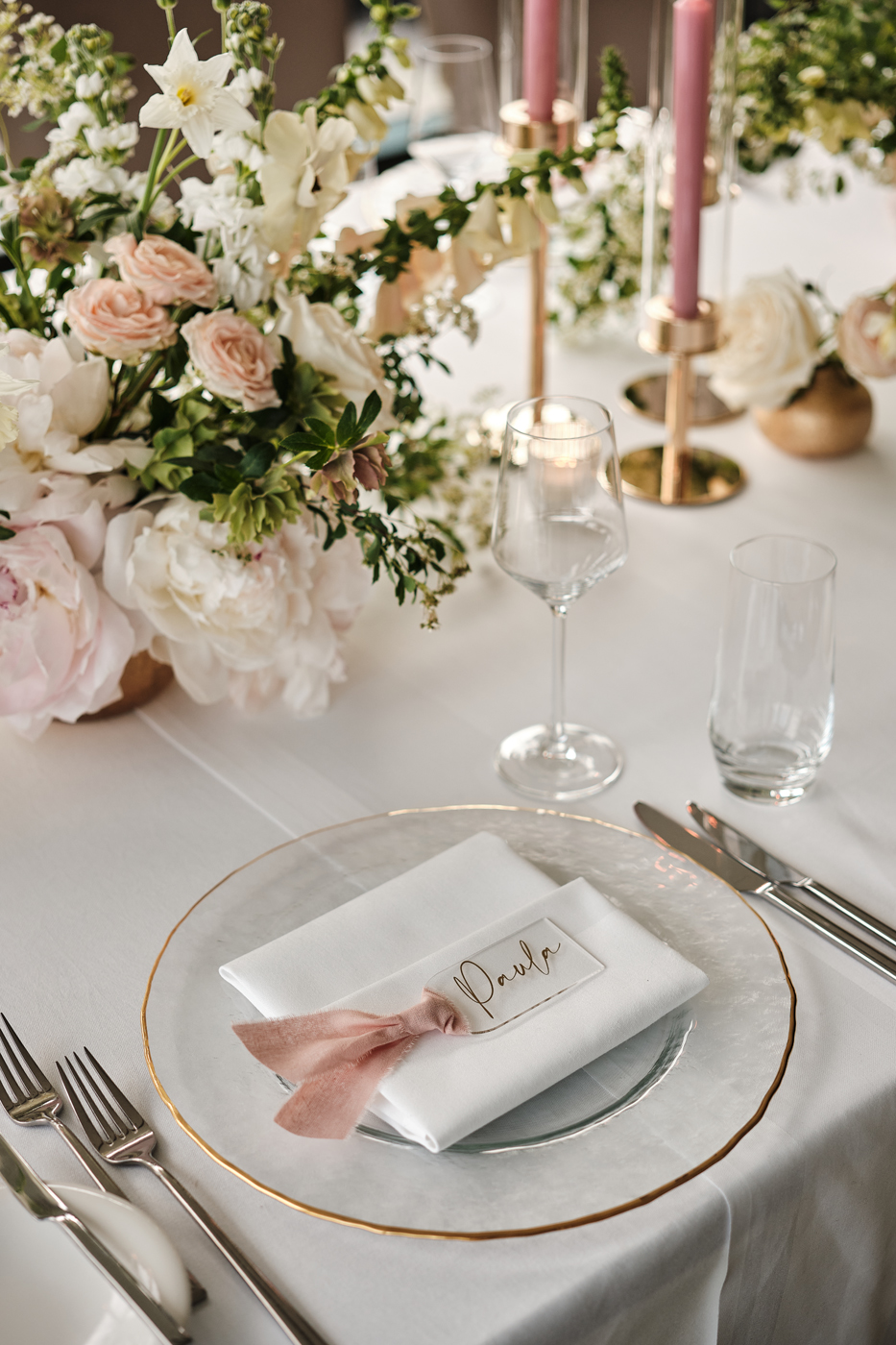 Hochzeitsdeko auf dem Tisch und ein Teller mit einem Platzkärtchen.